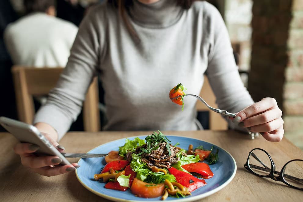 Expertos alertan que comer mirando el celular no solo distrae: cuáles son los efectos sobre el hambre, la saciedad y la ingesta